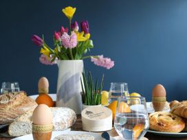 A dining room table set with food and flowers at The Old Post Box in 