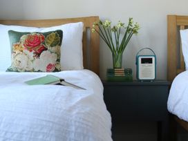 A bedroom with beds and a nightstand at The Old Post Box 