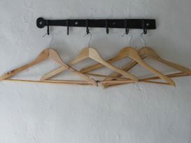 Hangers on a wall-mounted rack in a clothing storage area at The Old Post Box