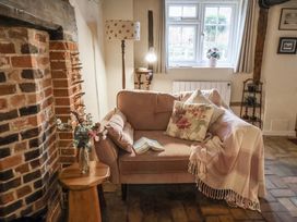 A living room with a sofa and fireplace at The Old Post Box in Halesworth