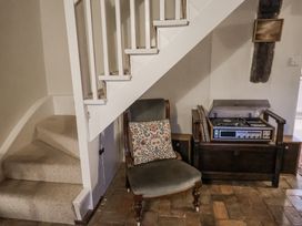 A living room with a chair and record player at The Old Post Box in Halesworth