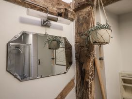 A bathroom with a mirror and hanging plant at The Old Post Box in Halesworth