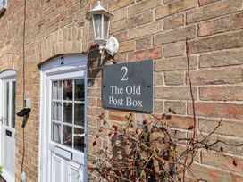 A house number and sign on a wall at The Old Post Box in Halesworth