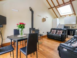 A living room with a dining table and chairs at The Owl Barn Cottage 