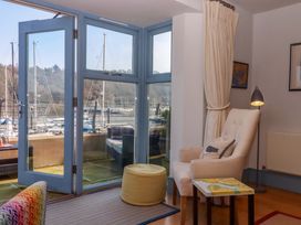A living room with an armchair and door opening to a marina view at 26 Dart Marina 