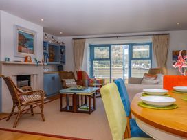 A living room with a sofa, coffee table, and dining area at 26 Dart Marina