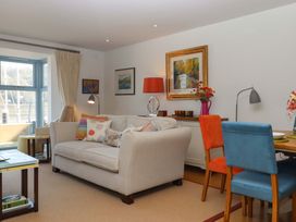 A living room with a sofa and dining area at 26 Dart Marina