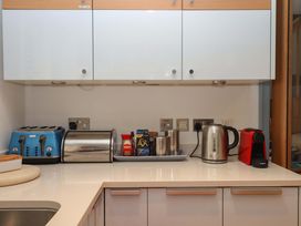 A kitchen counter with a kettle, toaster, coffee maker, and storage containers at 26 Dart Marina