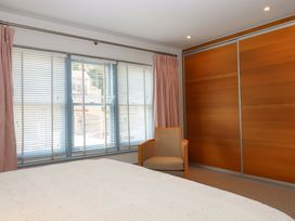 A bedroom featuring a bed, a chair, and a wardrobe at 26 Dart Marina