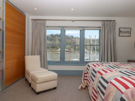 A bedroom with a bed and a view of the marina at 26 Dart Marina 