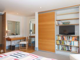 A bedroom with a desk, bookshelf, and television at 26 Dart Marina