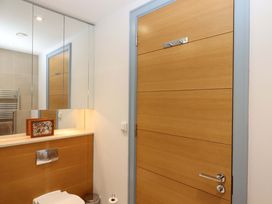 A bathroom with a wooden door and fixtures at 26 Dart Marina