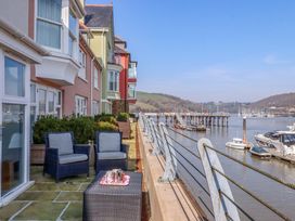 An outdoor seating area with chairs and table by the river at 26 Dart Marina
