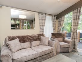 A living room with sofa and armchairs at Feather Hill Lodge in Windermere