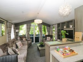 A living room with sofas and a coffee table at Feather Hill Lodge White Cross Bay near Troutbeck Bridge