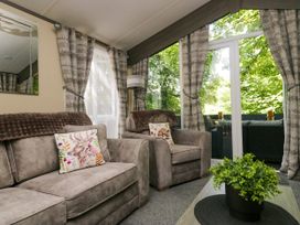 A living room with two armchairs and a table at Feather Hill Lodge White Cross Bay, Skiptory Howe 38 near White Cross Bay