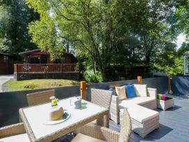 An outdoor seating area with a table and chairs at Feather Hill Lodge White Cross Bay, Skiptory Howe 38 near Troutbeck Bridge