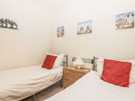 A bedroom with two beds and a nightstand at Mayflower View in Dawlish