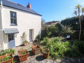 A garden with planters and a house at Pedn Brose Near Mousehole