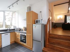 A kitchen with appliances and a staircase at The Old Sunday School Cwmwysg near Sennybridge