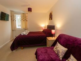 A bedroom with a bed and sofa at The Old Sunday School in Cwmwysg near Sennybridge