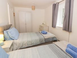 A bedroom with two beds and a cupboard at The Old Sunday School in Cwmwysg near Sennybridge
