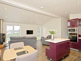 A living room with a sofa and dining area at Brayton in Aspatria