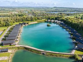 An aerial view of cabins surrounding a lake at Brayton in Aspatria