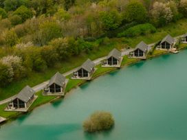 A row of houses by a body of water with trees in the background at Brayton in Aspatria