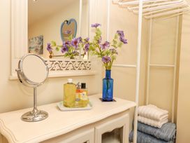 A bathroom with toiletries on a cabinet and towels stacked at Sea Folly