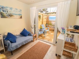 A living room with a sofa and sliding door at Sea Folly