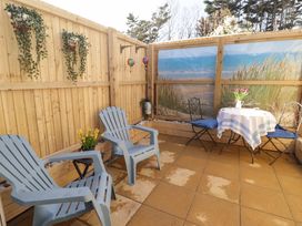 An outdoor patio with chairs and a table at Sea Folly 