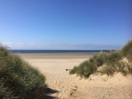 A beach scene with sand dunes and ocean view at Sea Folly in Porthcawl