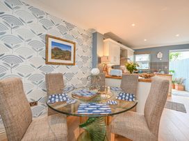 A dining room with a glass table and chairs at Lisburne Place in Torquay