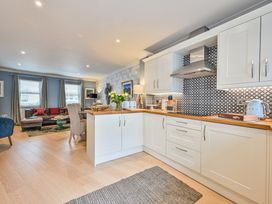 A kitchen with a living area in the background at Lisburne Place in Torquay
