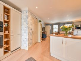 A kitchen with cabinets and a door at Lisburne Place in Torquay