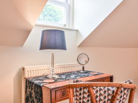 A desk with a lamp and mirror at Lisburne Place in Torquay