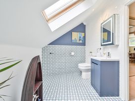 A bathroom with a sink, toilet, and mirror at Lisburne Place in Torquay