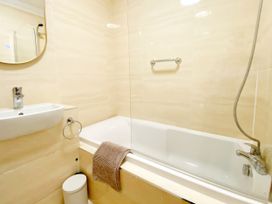A bathroom with a bathtub and wash basin at The Degas Sea View Suite Torquay