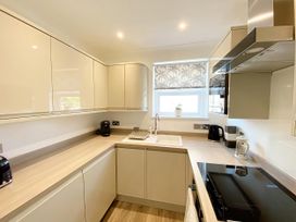 A kitchen with cabinets, sink and appliances at The Degas Sea View Suite in Torquay