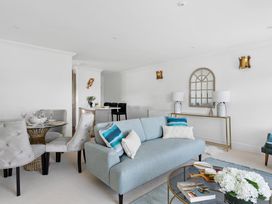 A living room with a sofa and dining area at The Renior Sea View Suite in Torquay