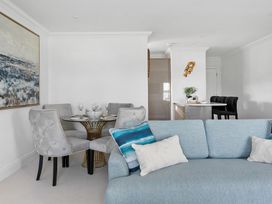 A living room with a dining area and sofa at The Renior Sea View Suite in Torquay
