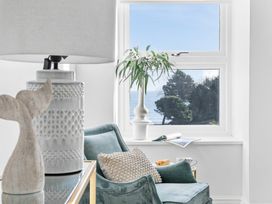 A living room with a chair and a window view at The Renior Sea View Suite in Torquay