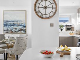 A kitchen with a dining area and fruit on the counter at The Renior Sea View Suite Torquay