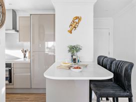 A kitchen with a counter and bar stools at The Renior Sea View Suite in Torquay