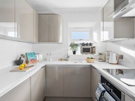 A kitchen with cabinets and countertop at The Renior Sea View Suite in Torquay