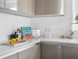 A kitchen with a sink, cutting board and book at The Renior Sea View Suite in Torquay