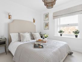 A bedroom with a bed, bedside table, and plants at The Renior Sea View Suite in Torquay