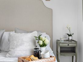 A bedroom with a bed and a tray of breakfast items at The Renior Sea View Suite in Torquay