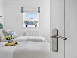 A bedroom with two beds and a window at The Renior Sea View Suite in Torquay